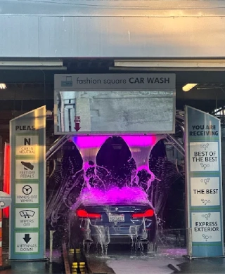 Car entering the Fashion Square Car Wash express exterior wash tunnel with colorful lighting